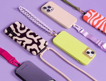 Different colored phone cases with phone cords laying on a purple background